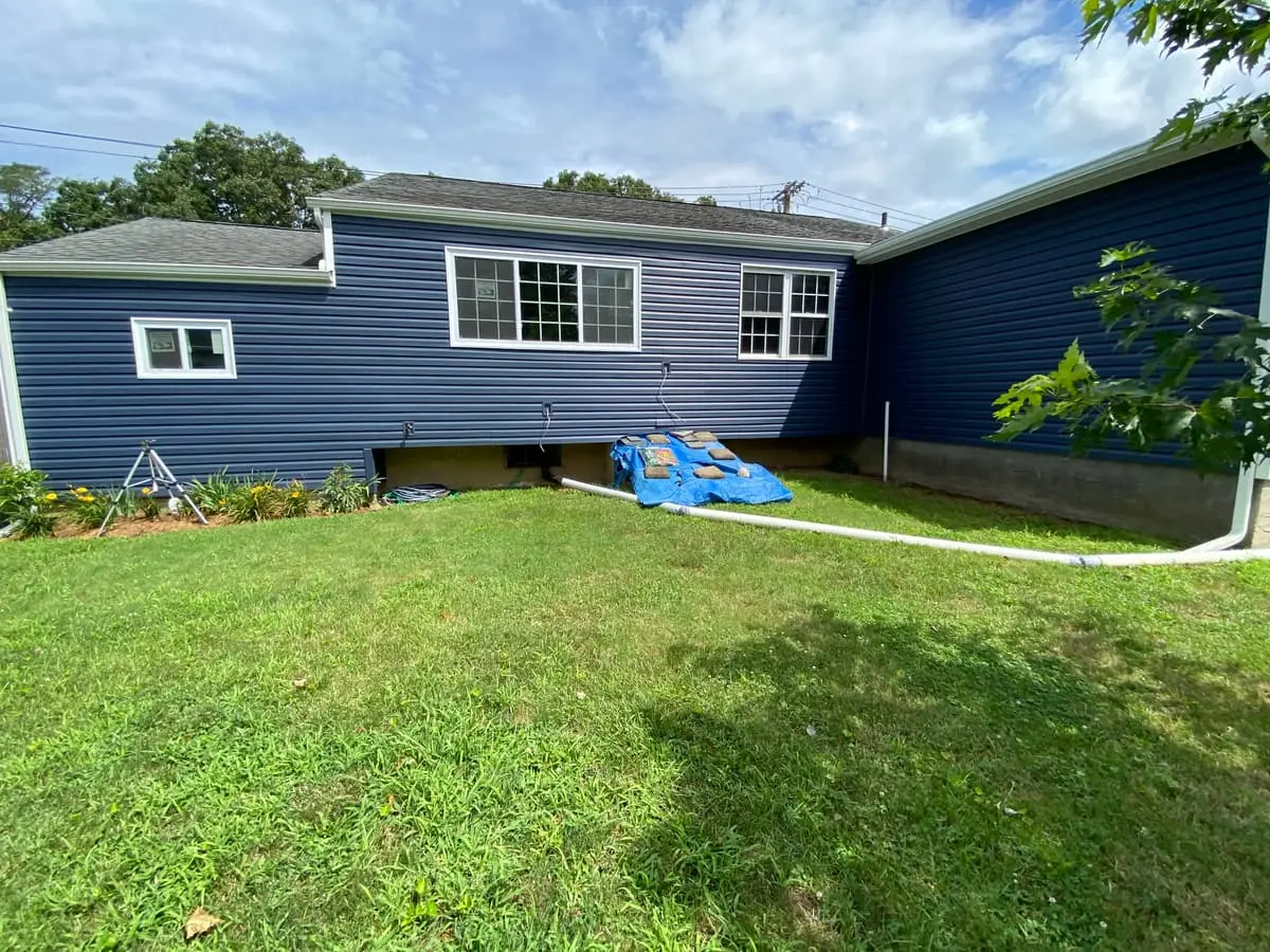 Selling a house after a life change in Bay Shore: rear of a ranch with new navy siding