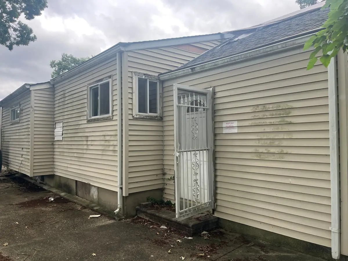 Trying to stop a foreclosure in Bay Shore: side of a vacant ranch with a security door